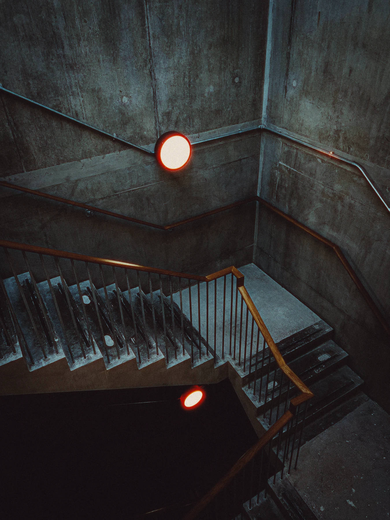 A stairwell lamp with warm red halation around the light